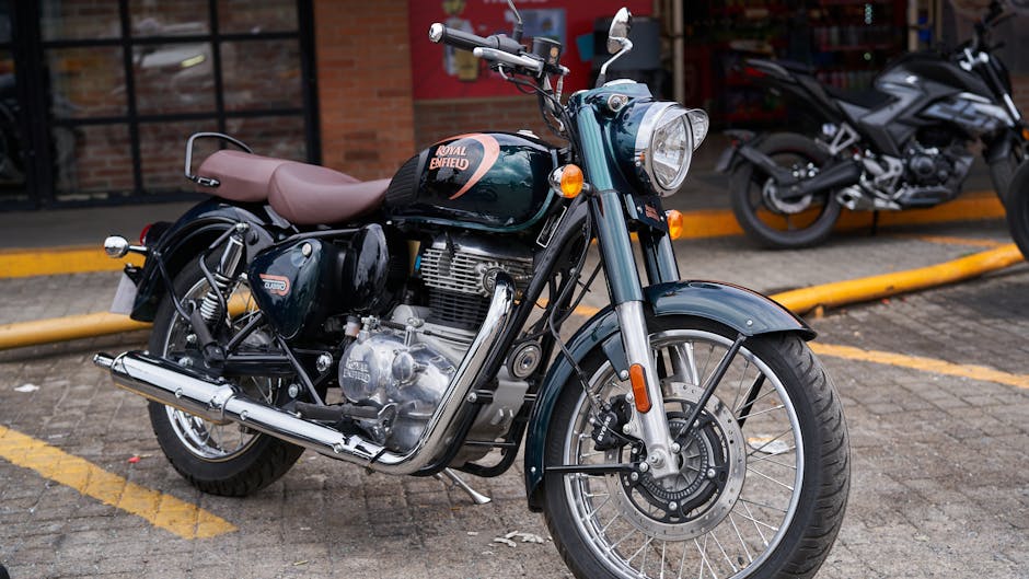 A black motorcycle with a streamlined design is parked on the side of a rural road, featuring dual rearview mirrors, a round headlamp, and an orange indicator light on each side. The motorcycle has a matte black engine, exhaust pipe, and wheels, with a grey seat extending over the frame. In the background, there are tall, evenly spaced streetlights lining the road, which curves slightly to the left. The sky appears overcast with a muted light, and distant hills covered with trees are visible on the horizon. The scene suggests a quiet area suitable for home relocation or vehicle transportation, illustrating the kind of transport used in moving and logistics services. The company Man with Van Enfield Highway specializes in removals and furniture transport, supporting home relocation and packing and moving processes. The motorcycle is parked close to the pavement, captured in a still position, emphasizing the importance of secure vehicle storage during a move.